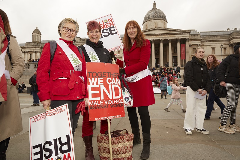 Three WI members with signs at the Million Women Rise march in London 2020