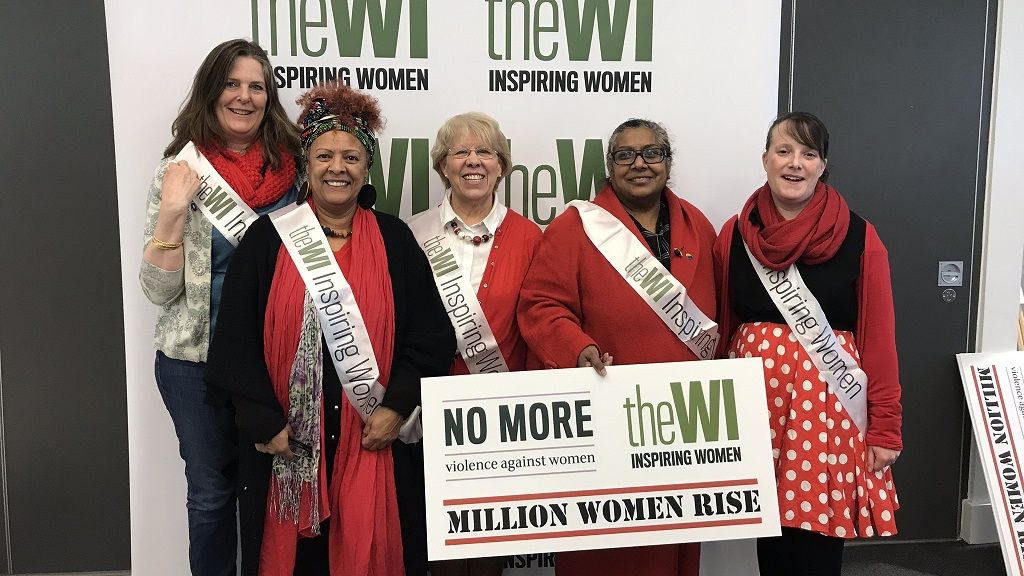 A group of women in front of a WI Logo wall at the Million Women Rise March 2020