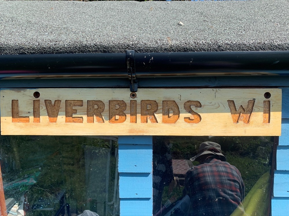 A wooden sign that reads Liverbirds WI