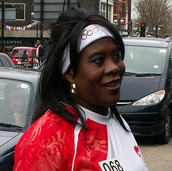 Tessa Sanderson on the street wearing a sports outfit giving an interviiew